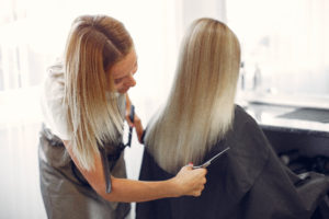 Hairdresser cut hair her client in a hair salon habia